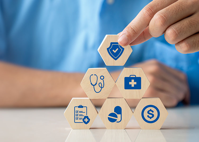 Health insurance concept. Hand holding wooden cube with healthcare medical icon. Family life insurance and policy concepts, hospital, medical treatment